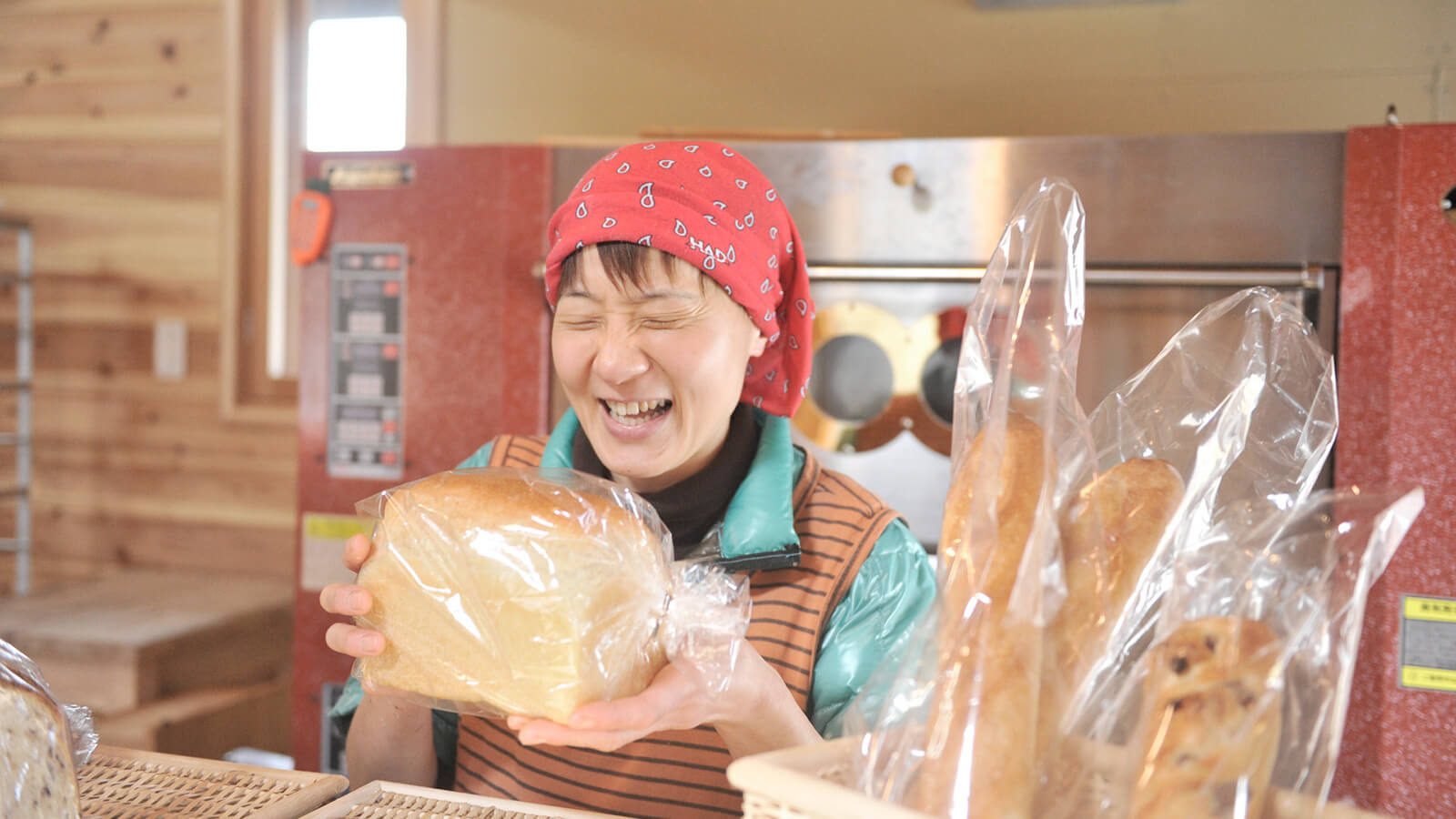 焼き上がったパンを手に笑顔の伊富貴さん
